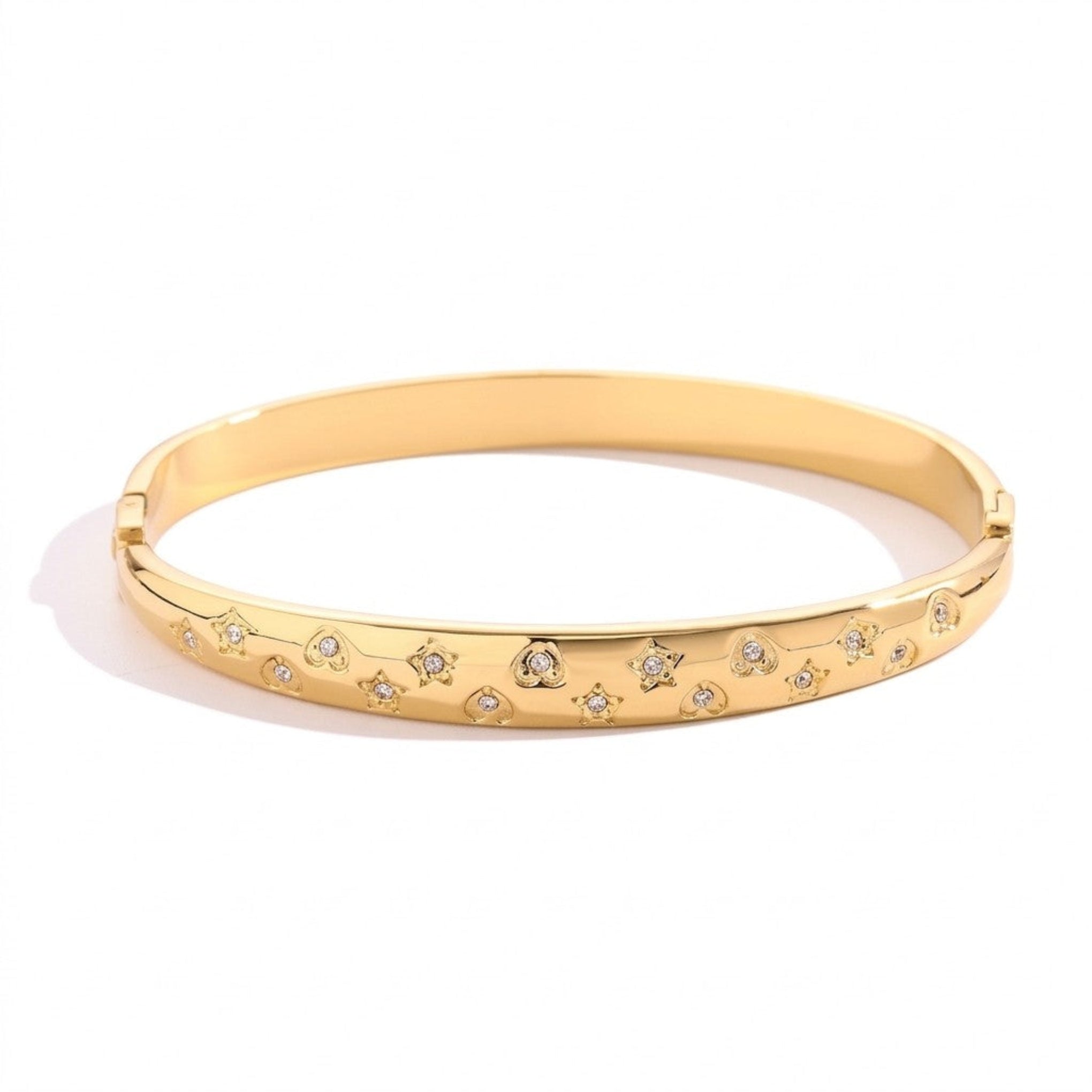 Top-down view of a gold celestial bangle with engraved stars and hearts on a white background, 18k gold plated stainless steel jewelry