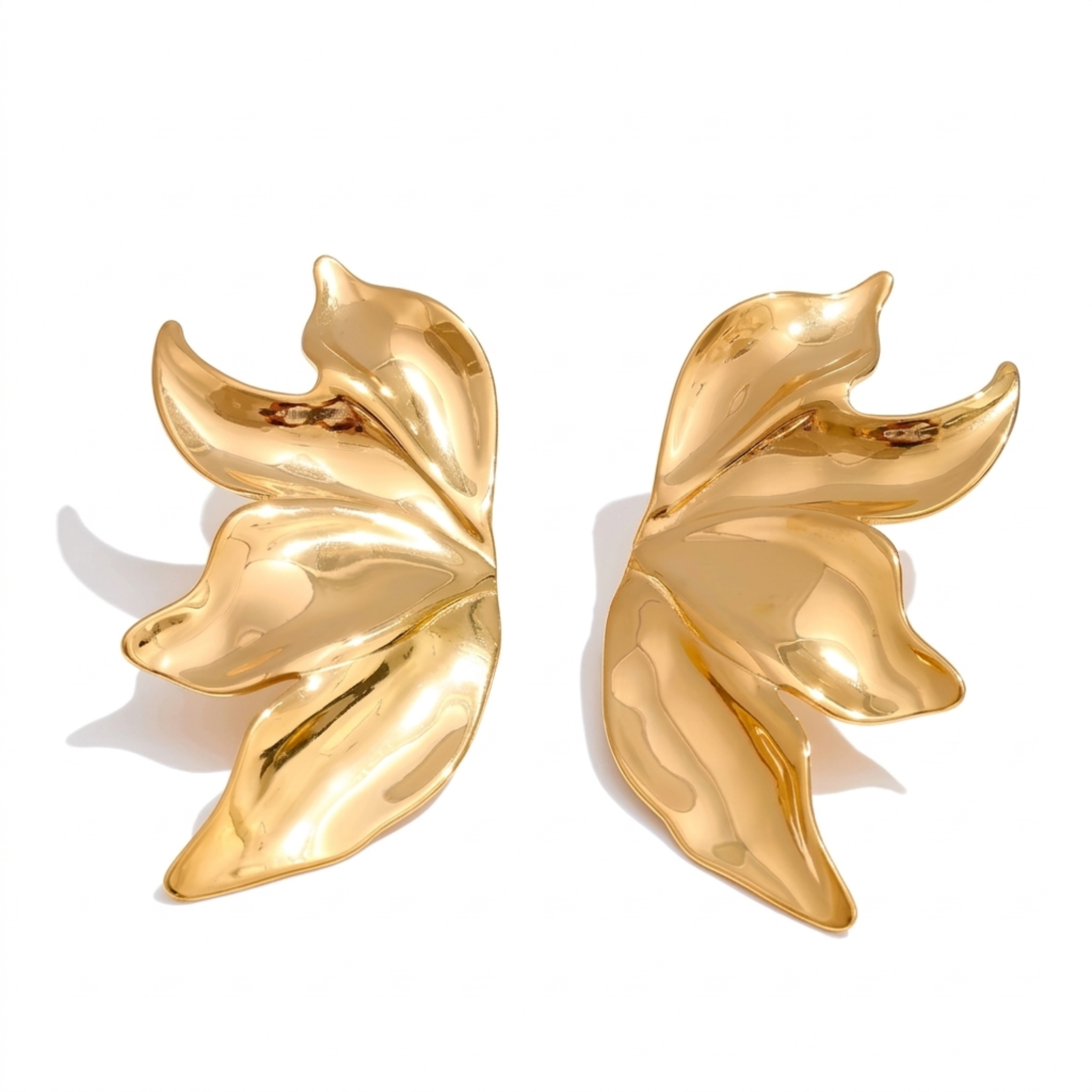 Pair of gold leaf-shaped earrings on a white background