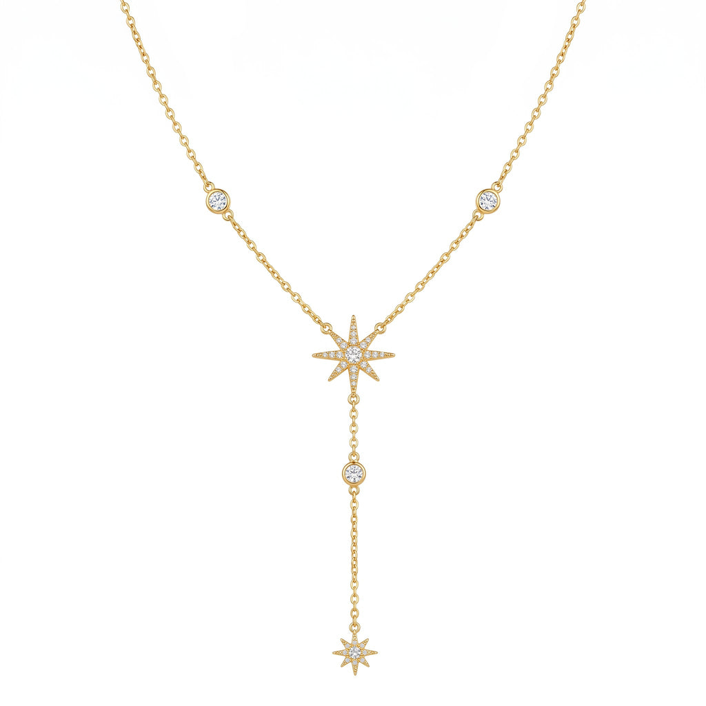 A gold double-layered necklace featuring a Y-shaped drop design with three starburst charms, each adorned with small clear pavé stones, and accent round bezel-set stones along the chain, shown on a plain white background.